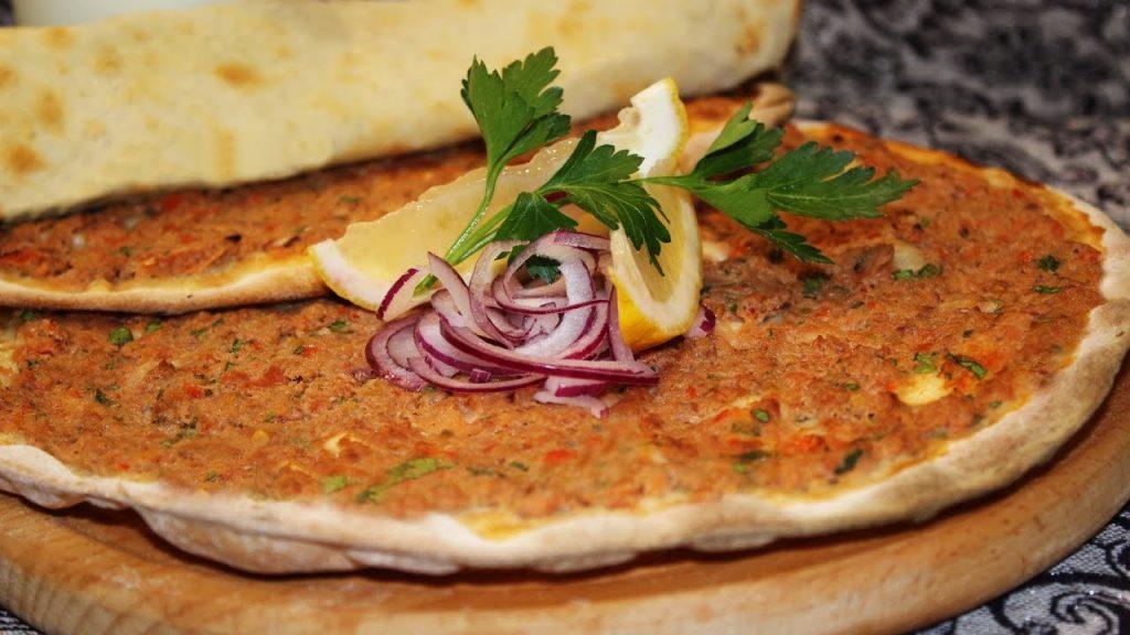 Лахмаджун (Lahmacun)  - это традиционное блюдо Турции, состоящее из тонкой лепешки, приправленной томатной пастой, овощами и мелко нарезанным мясом. 